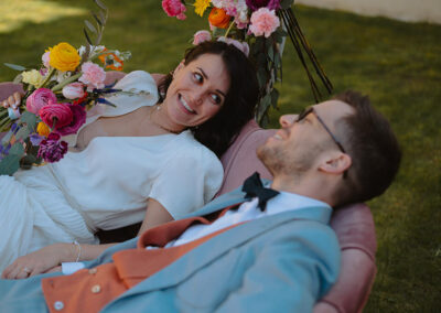 couple de jeunes mariés allongé dans un canapé fleuri