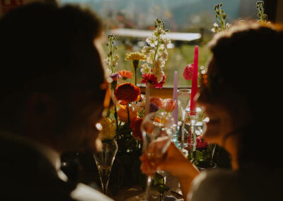 couple de jeunes mariés contre jour devant fleur